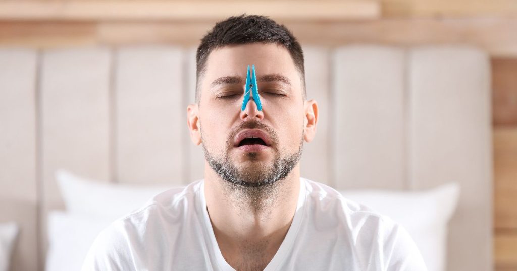 barbat cu deviatie de sept si un cleste de rufe prins pe nas