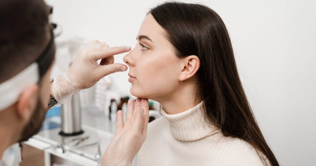 pacienta alaturi de medic dupa o operatie de rinoplastie